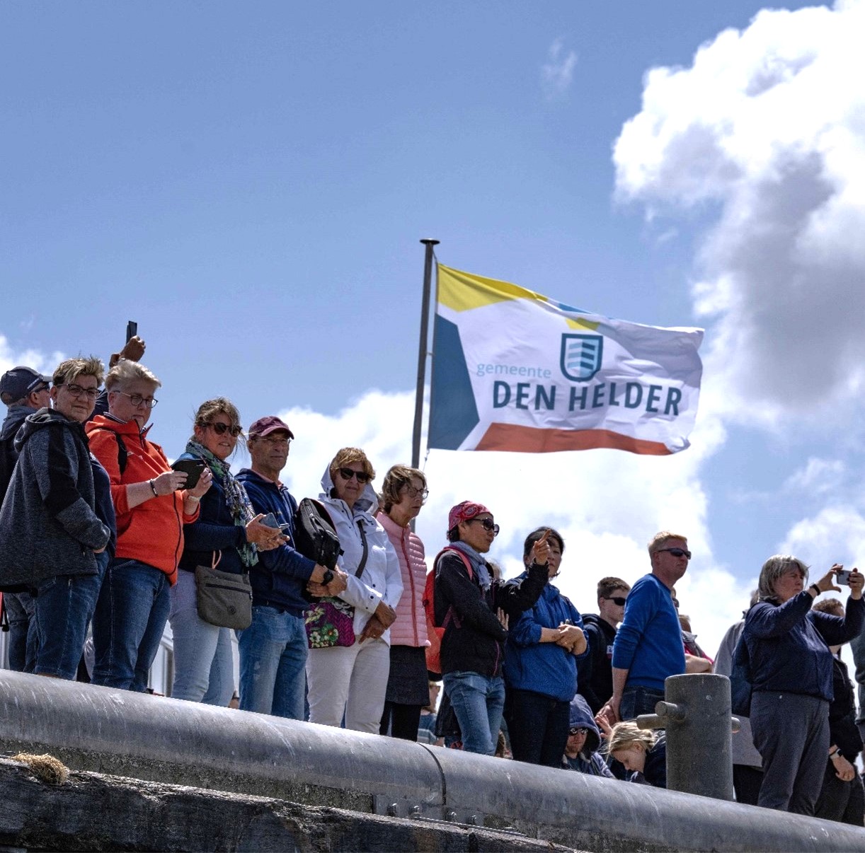Groep mensen met een vlag van gemeente Den Helder